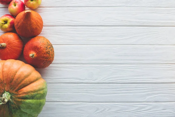 Top view of autumnal ripe pumpkins and apples on wooden tabletop — Stock Photo