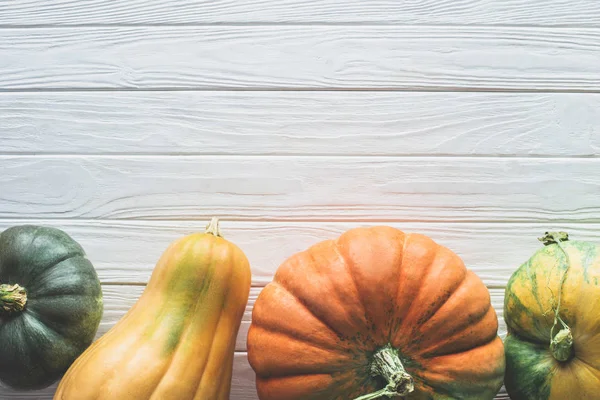 Top view of green, yellow and orange pumpkins on tabletop — Stock Photo