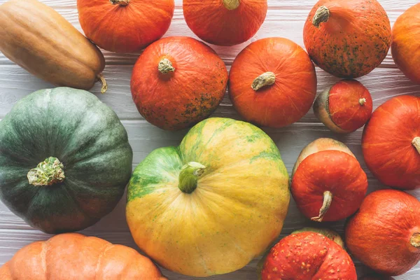 Top view of pile of ripe autumnal pumpkins on wooden tabletop — Stock Photo