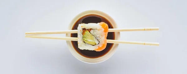 Nahaufnahme von köstlichem Sushi und Essstäbchen mit Sojasauce in Schüssel isoliert auf weiß — Stockfoto