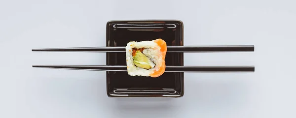 Vue rapprochée de savoureux sushis et baguettes isolés sur blanc — Photo de stock