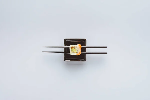 Top view of tasty sushi and chopsticks isolated on white — Stock Photo