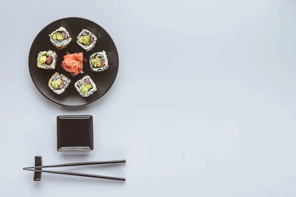 Vue de dessus de délicieux sushis au gingembre et baguettes isolées sur blanc — Photo de stock