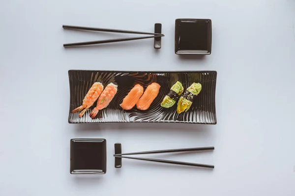 Vista dall'alto del gustoso set di sushi e bacchette isolate su bianco — Foto stock