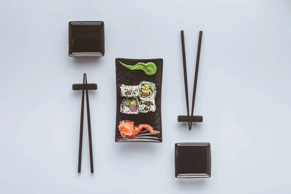 Vista superior de sushi gourmet con palillos, jengibre y wasabi aislados en blanco - foto de stock