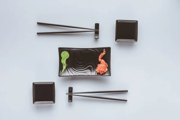 Vista superior de pauzinhos e wasabi com gengibre para comer sushi isolado em branco — Fotografia de Stock