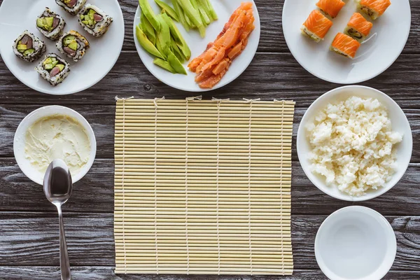 Вид ингредиентов для приготовления вкусных суши на деревянном столе — стоковое фото
