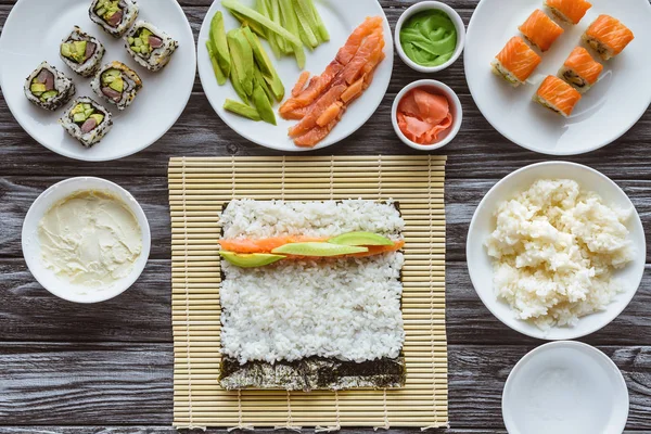 Vista superior de los ingredientes para cocinar sushi delicioso en la mesa - foto de stock