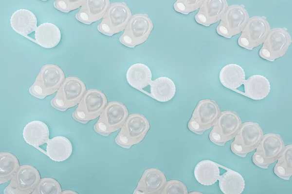 Top view of contact lenses in containers arranged on blue background — Stock Photo