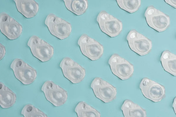 Full frame of contact lenses in containers arranged on blue background — Stock Photo