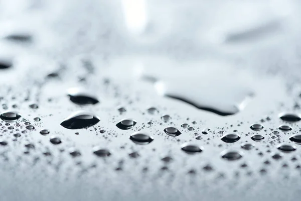 Vista de cerca de las gotas de agua en la superficie gris como fondo - foto de stock