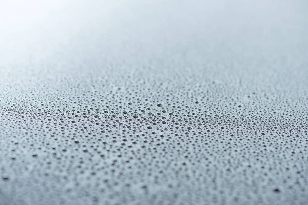 Vista de cerca de las gotas de agua en la superficie gris como fondo - foto de stock