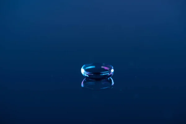 Vista cercana de la lente de contacto en el fondo azul - foto de stock