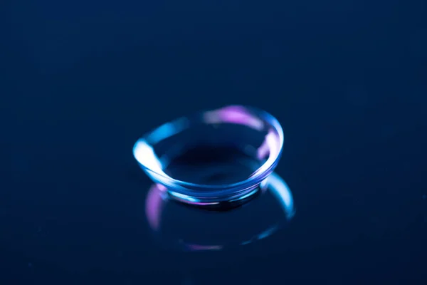 Vista cercana de la lente de contacto en el fondo azul - foto de stock