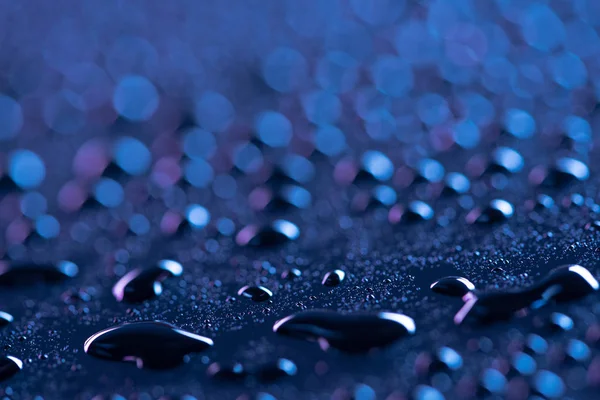 Vista de perto de gotas de água na superfície azul como fundo — Fotografia de Stock