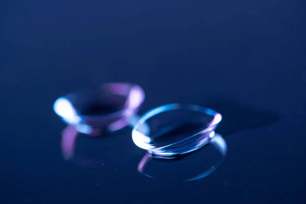 Selective focus of contact lenses arranged on blue backdrop — Stock Photo