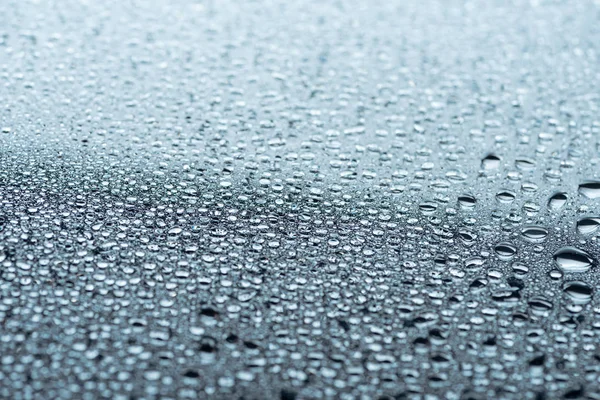 Vista de cerca de las gotas de agua en la superficie gris como fondo - foto de stock