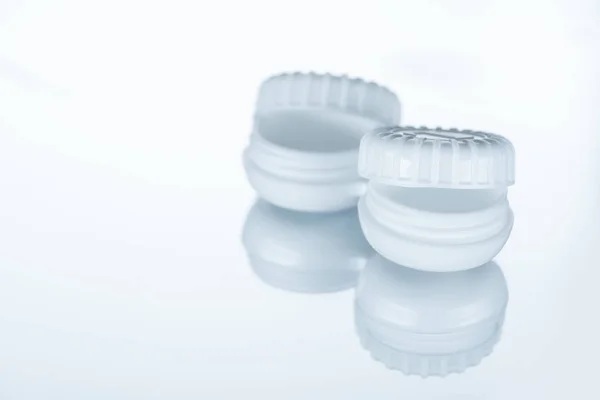 Nahaufnahme eines leeren Behälters für Kontaktlinsen auf weißem Hintergrund mit Reflexion — Stockfoto
