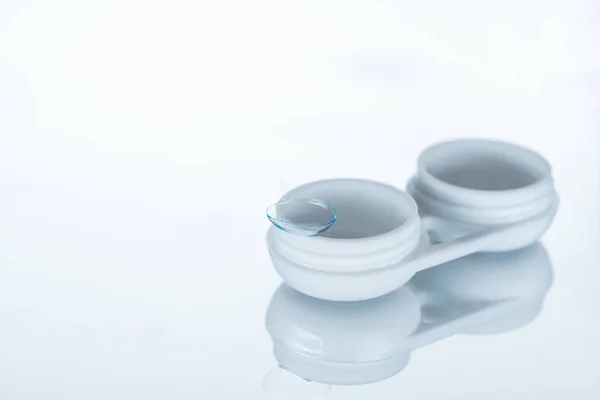 Vista ravvicinata della lente a contatto e del contenitore su sfondo bianco — Foto stock