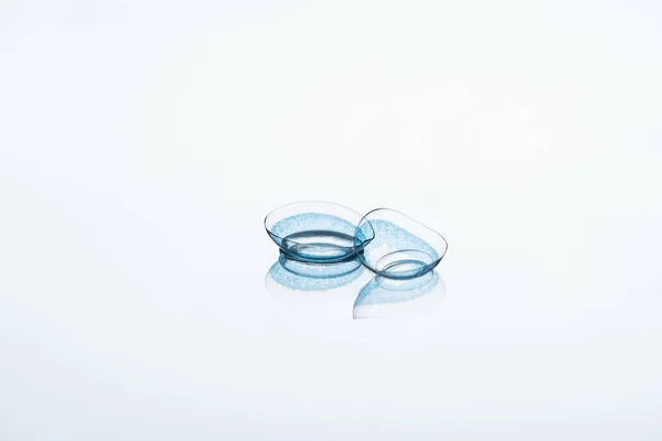 Close up view of contact lenses arranged on white backdrop — Stock Photo