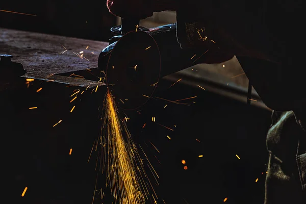 Обрезанный образ производственного работника с помощью циркулярной пилы с блестками на заводе — стоковое фото