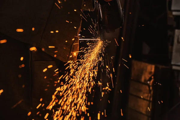Обрезанный образ производственного работника с помощью циркулярной пилы с блестками на заводе — стоковое фото