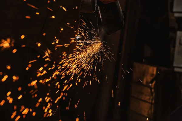 Vista parcial del trabajador de fabricación utilizando sierra circular con destellos en fábrica - foto de stock