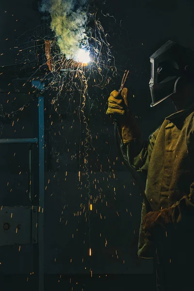 Trabajador en la máscara de protección de soldadura de metal en fábrica - foto de stock