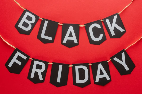 Black friday words on flag garlands isolated on red — Stock Photo