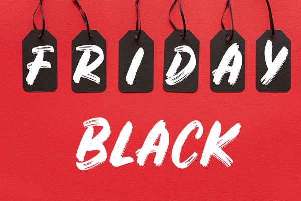 Black sale tags isolated on red with black friday lettering — Stock Photo