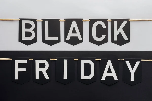 Black friday lettering on flag garlands on black and white background — Stock Photo