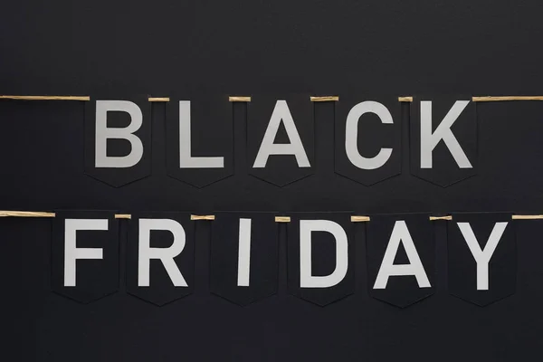 Black friday lettering on flag garlands in lines on black — Stock Photo