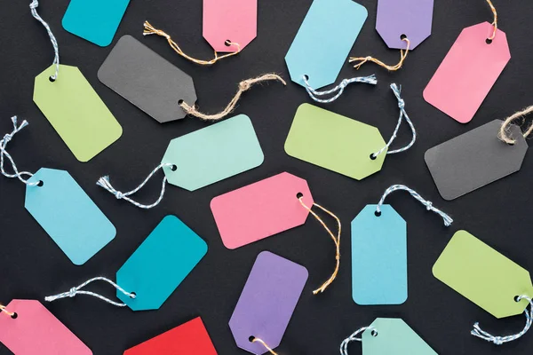 Top view of empty colorful sale tags on black background for black friday — Stock Photo