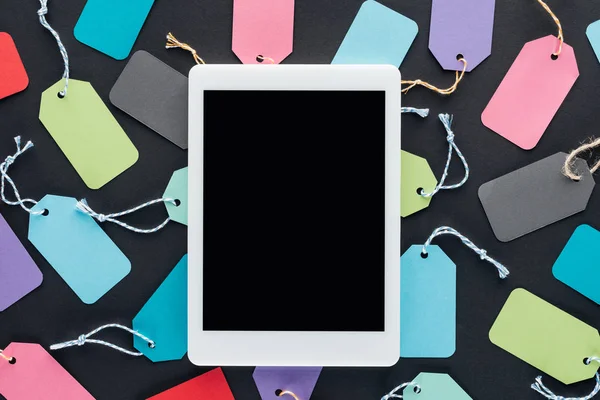 Top view of digital tablet with blank screen on colorful sale tags — Stock Photo