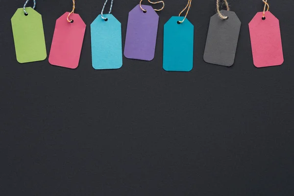 Top view of colorful sale tags on black background with copy space for black friday — Stock Photo