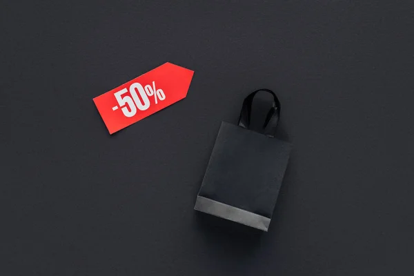 Top view of shopping bag and sale tag with fifty percents discount for black friday — Stock Photo