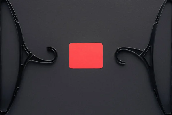Vista superior de cabides e cartão vermelho vazio para sexta-feira preta — Fotografia de Stock