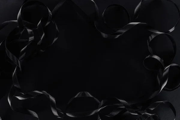 Vista superior de cintas brillantes sobre fondo negro con espacio de copia para el viernes negro — Stock Photo