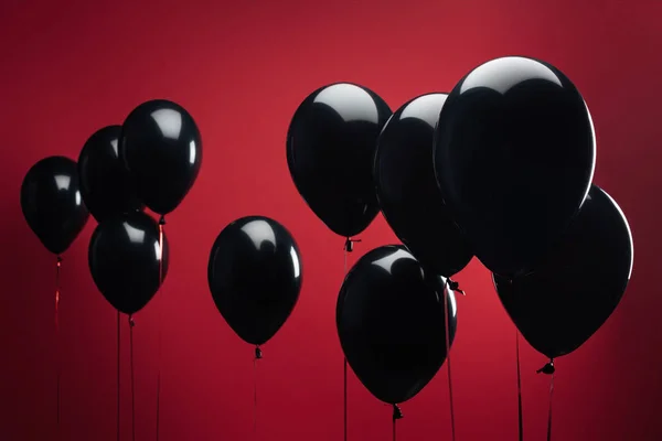 Фон с черными воздушными шарами на красном для черной пятницы — стоковое фото