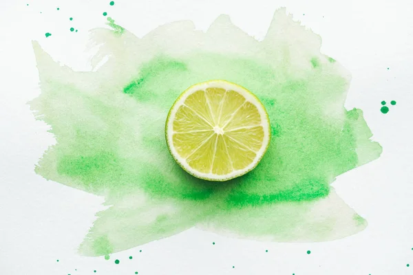Top view of piece of ripe citrus on white surface with green watercolor — Stock Photo