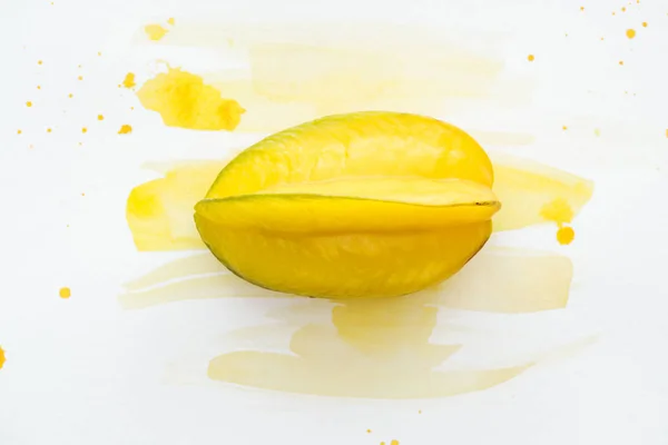 Top view of carambola on white surface with yellow watercolor — Stock Photo