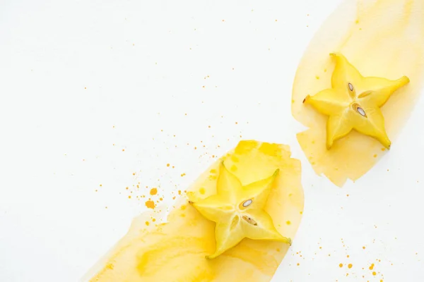 Top view of sweet star fruits on white surface with yellow watercolor — Stock Photo