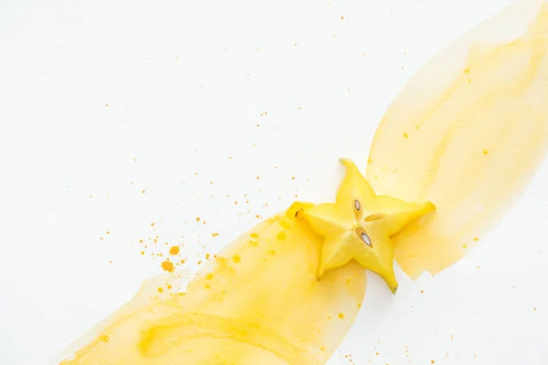 Top view of star fruit on white surface with yellow watercolor — Stock Photo