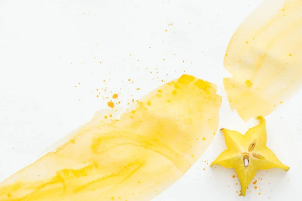 Top view of sweet yummy star fruit on white surface with yellow watercolor — Stock Photo
