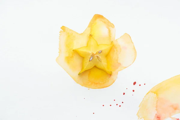 Vista superior de la deliciosa fruta estrella amarilla en la superficie blanca con acuarela amarilla - foto de stock