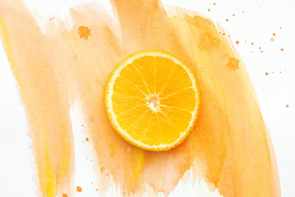 Top view of orange piece on white surface with orange watercolor — Stock Photo