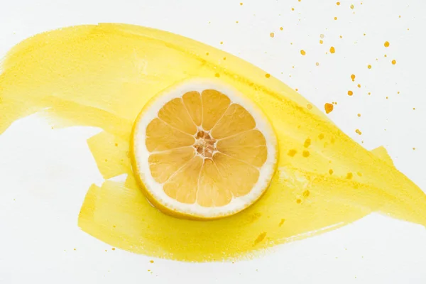 Top view of lemon piece on white surface with yellow watercolor — Stock Photo