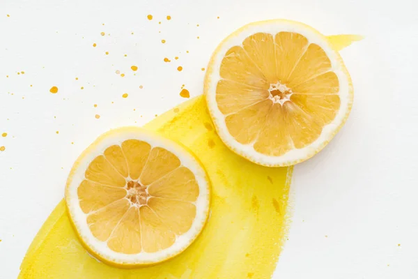 Top view of citrus pieces on white surface with yellow watercolor — Stock Photo