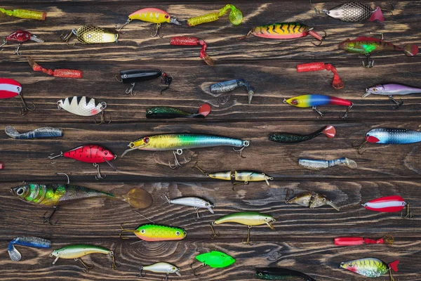 Flat lay with arranged various fishing bait on wooden background — Stock Photo