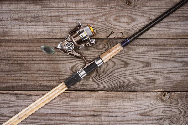 Elevated view of fishing rod on wooden background, minimalistic concept — Stock Photo